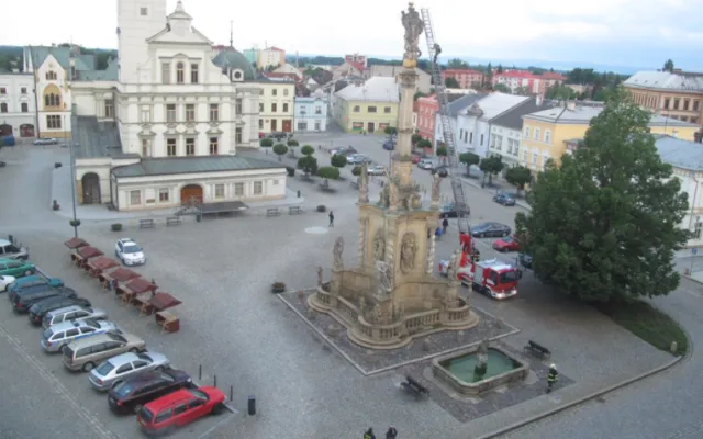 FOTO: Opilec vylezl na samotnou spičku morového sloupu v Uničově. Dolů mu museli pomoci hasiči