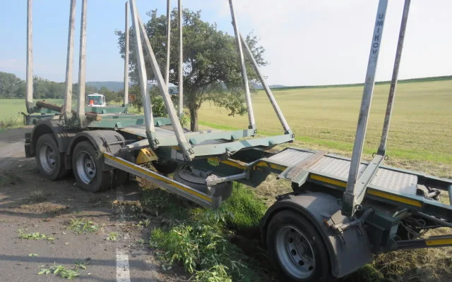 Řidič kamionu se dřevem nevybral zatáčku a skončil s vysypaným nákladem v poli