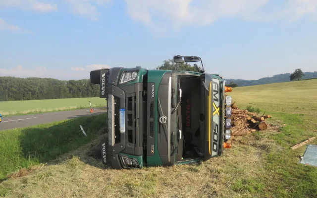 Řidič kamionu se dřevem nevybral zatáčku a skončil s vysypaným nákladem v poli
