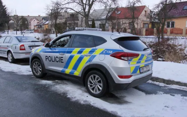 FOTO: Mladík bezdůvodně zaútočil na policistu, který seděl v autě. Na služebně pak prokopl dveře