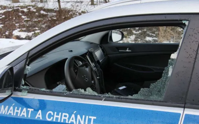 FOTO: Mladík bezdůvodně zaútočil na policistu, který seděl v autě. Na služebně pak prokopl dveře