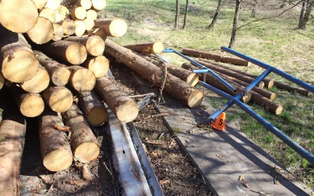 Řidič při projíždění zatáčkou převrátil přívěs s dřevěnými kládami