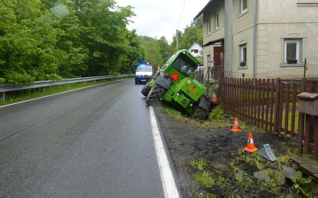 FOTO: Řidič zemědělského stroje sjel z cesty a opřel se o plot rodinného domu