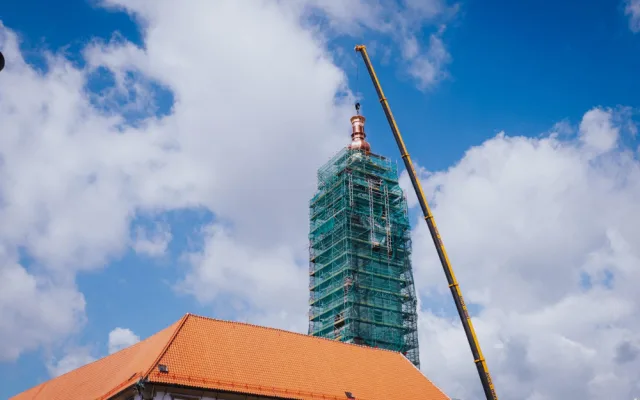 FOTO/VIDEO: Jeřáb dnes na olomouckou radnici vyzvedl prostřední část opravené věže