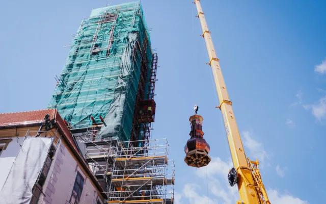 FOTO/VIDEO: Jeřáb dnes na olomouckou radnici vyzvedl prostřední část opravené věže