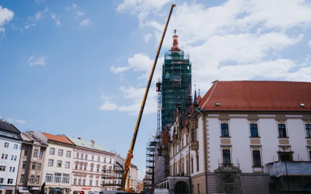 FOTO/VIDEO: Jeřáb dnes na olomouckou radnici vyzvedl prostřední část opravené věže