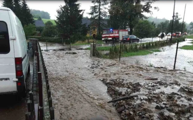 Silný déšť zvedl říčku Bělou na Jesenicku na třetí stupeň, zaplavila silnici. Hasiči čerpají vodu