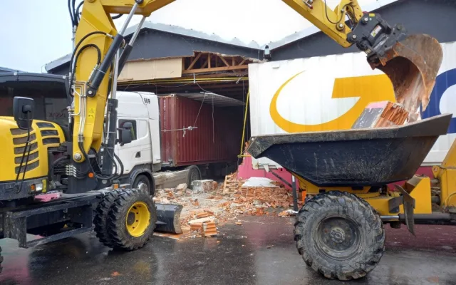 Neplánovaná demolice. Kamion při výjezdu z haly utrhl kus zdi, vůz vyprošťují hasiči