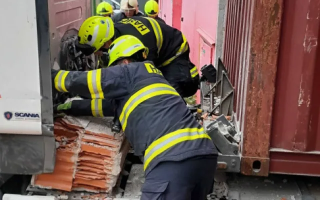 Neplánovaná demolice. Kamion při výjezdu z haly utrhl kus zdi, vůz vyprošťují hasiči