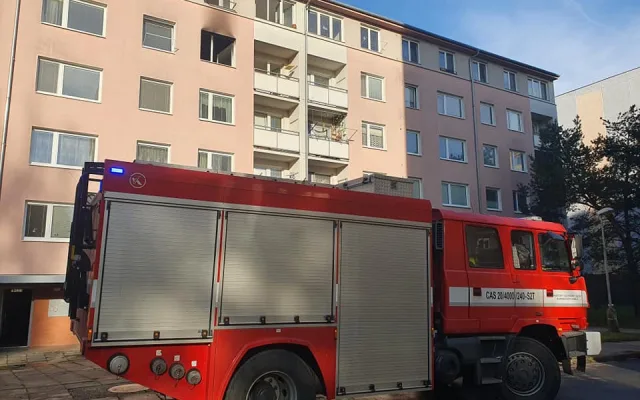 Požár v paneláku na Na Černé cestě. Hasiči z hořícího bytu zachránili jednu osobu, přiletěl pro ni vrtulník