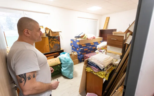 Jeden z klientů centra ukazuje sklad s materiálem a nábytkem