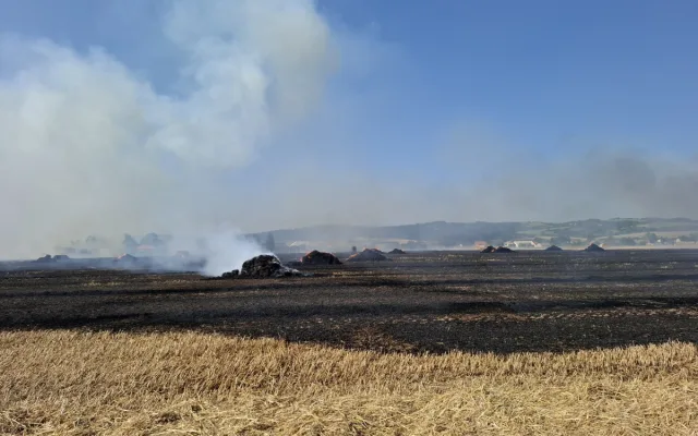 Padesát balíků slámy v plamenech. Hasiči likvidovali požár pole a zemědělského stroje u Dlouhé Loučky