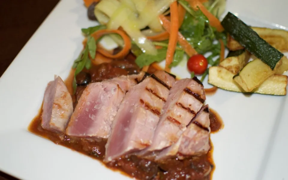 Grilovaný steak z čerstvého tuňáka s červeným vínem, kapari a olivovou omáčkou, cuketové hranolky a svěží míchaný salát