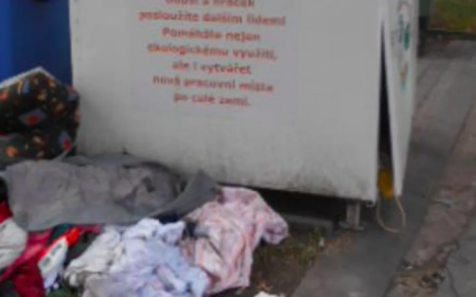 Vandal poškodil v centru města kontejner na oblečení. Oděvy se válely všude okolo