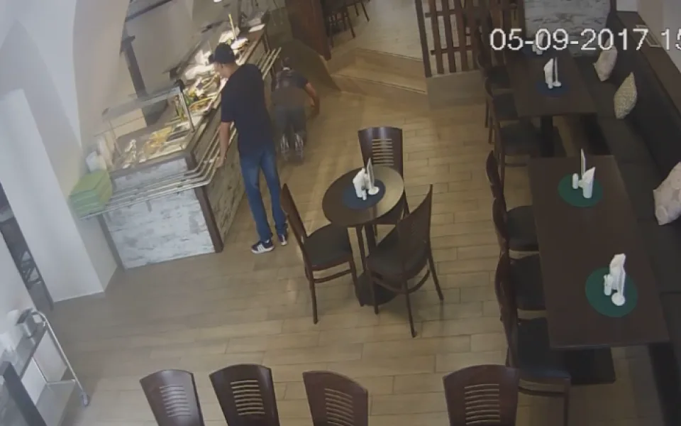 VIDEO: Zatímco jeden muž zabavil obsluhu v restauraci, druhý ukradl peníze. Zachytila je kamera
