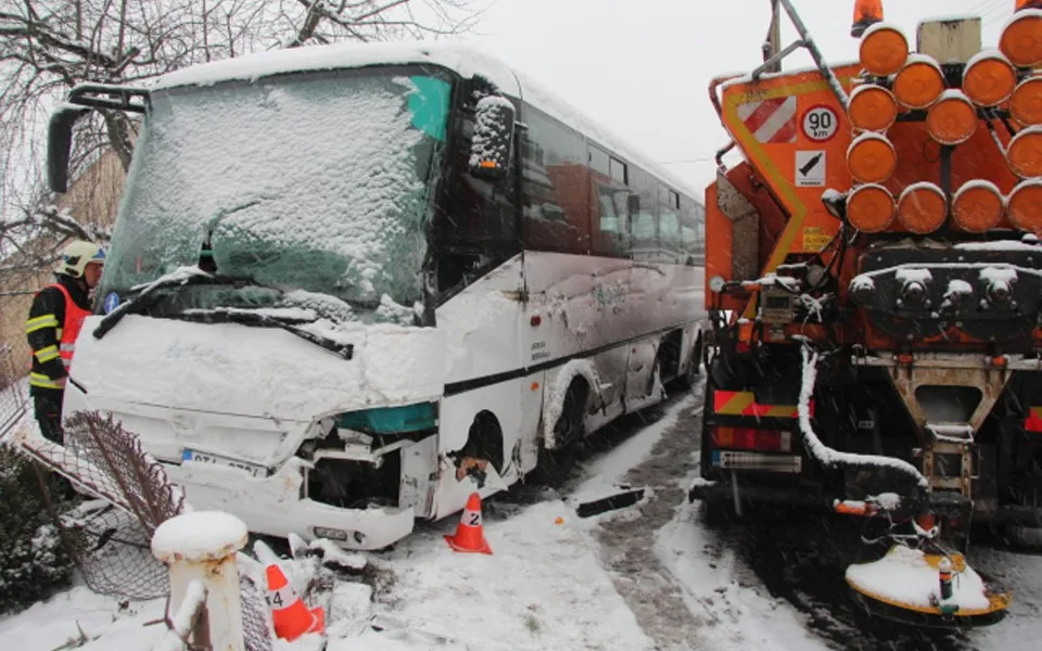 Autobus se srazil se sypačem a skončil v plotu rodinného domu, řidič byl převezen do nemocnice