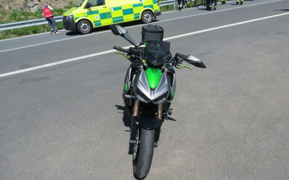 Motorkář dostal v zatáčce smyk, se svým strojem se po zemi sunul až ke svodidlům
