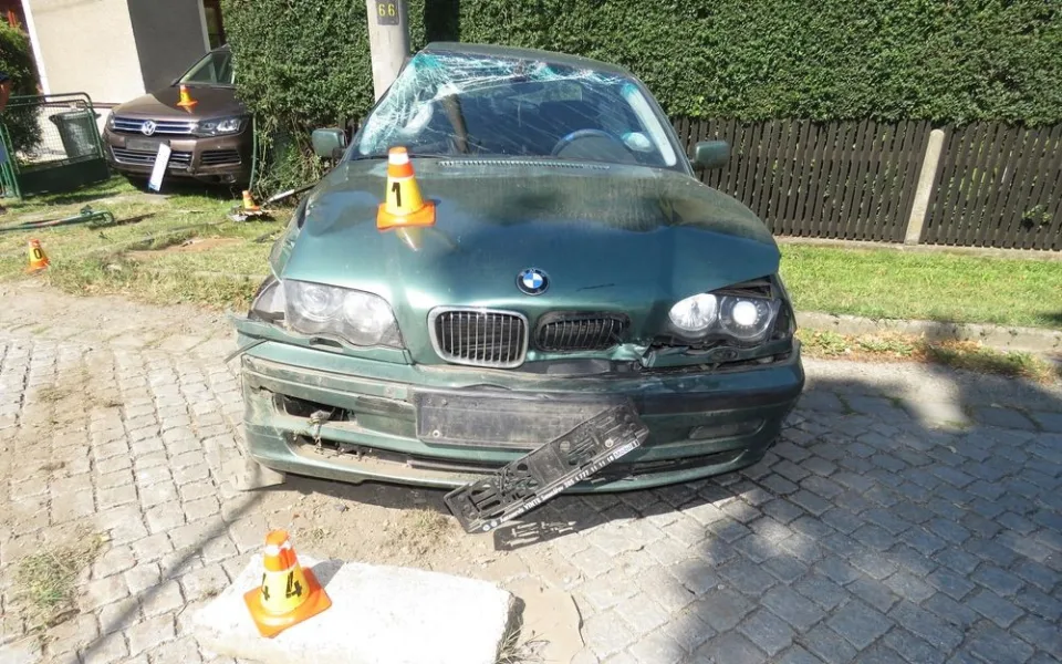 Řidič dostal smyk. Naboural zaparkované auto, plot domu a sloup vysokého napětí