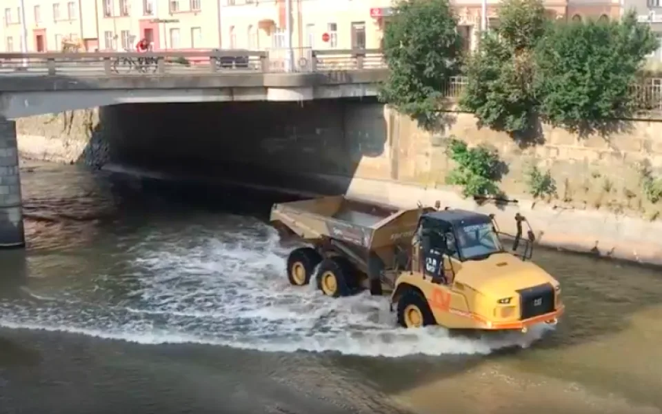 VIDEO: Stavební stroje se brodí korytem Moravy a odvážejí suť ze zbouraného mostu. Podívejte se