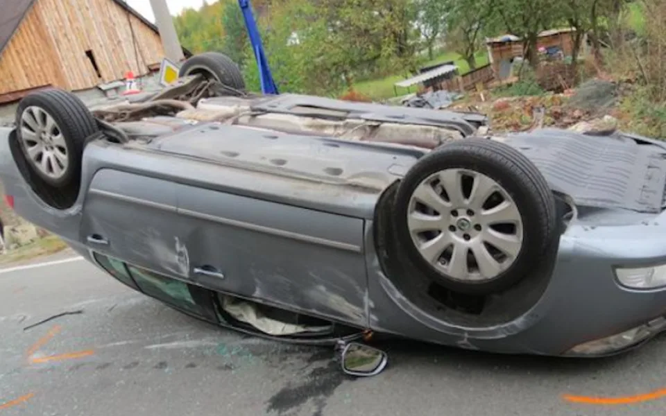Řidička narazila se svým Superbem do kamenné zídky, urvala kolo a auto přetočila na střechu