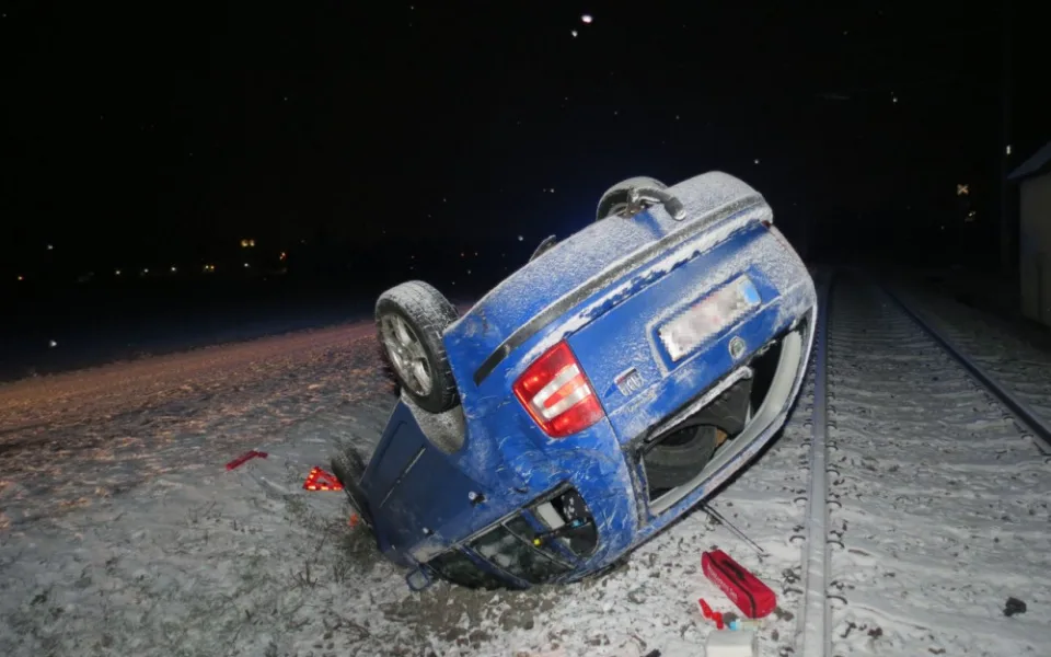 Mladá řidička dostala smyk na zasněžené silnici. Auto se převrátilo na střechu