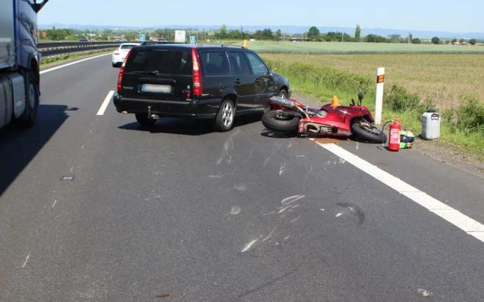 Motorkář předjížděl kolonu na dálnici po středové čáře. Srazil se s autem a skončil v nemocnici