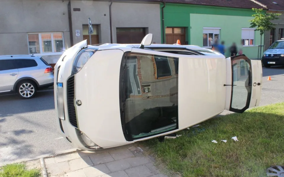 Žena bez řidičáku při couvání nabourala projíždějící auto. To skončilo na boku