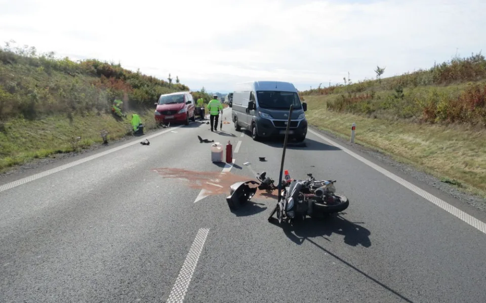 Motorkář se díval do zpětného zrcátka a přehlédl auto s přívěsem před ním. Po nárazu upadl na silnici