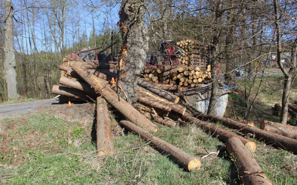 Řidič při projíždění zatáčkou převrátil přívěs s dřevěnými kládami