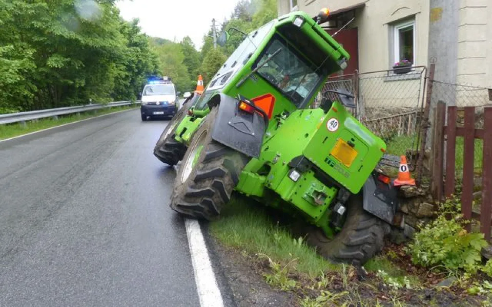 FOTO: Řidič zemědělského stroje sjel z cesty a opřel se o plot rodinného domu