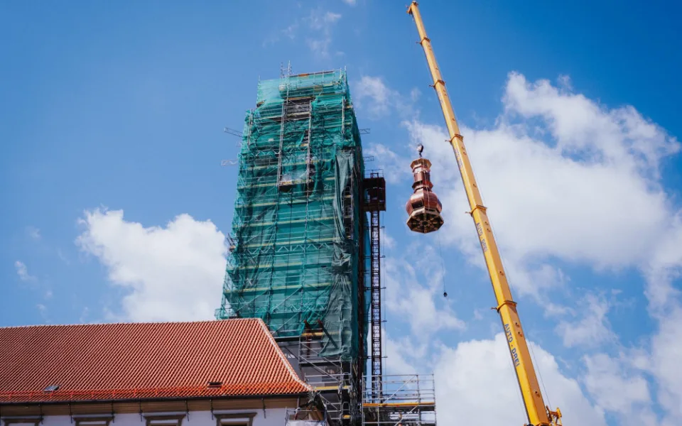 FOTO/VIDEO: Jeřáb dnes na olomouckou radnici vyzvedl prostřední část opravené věže