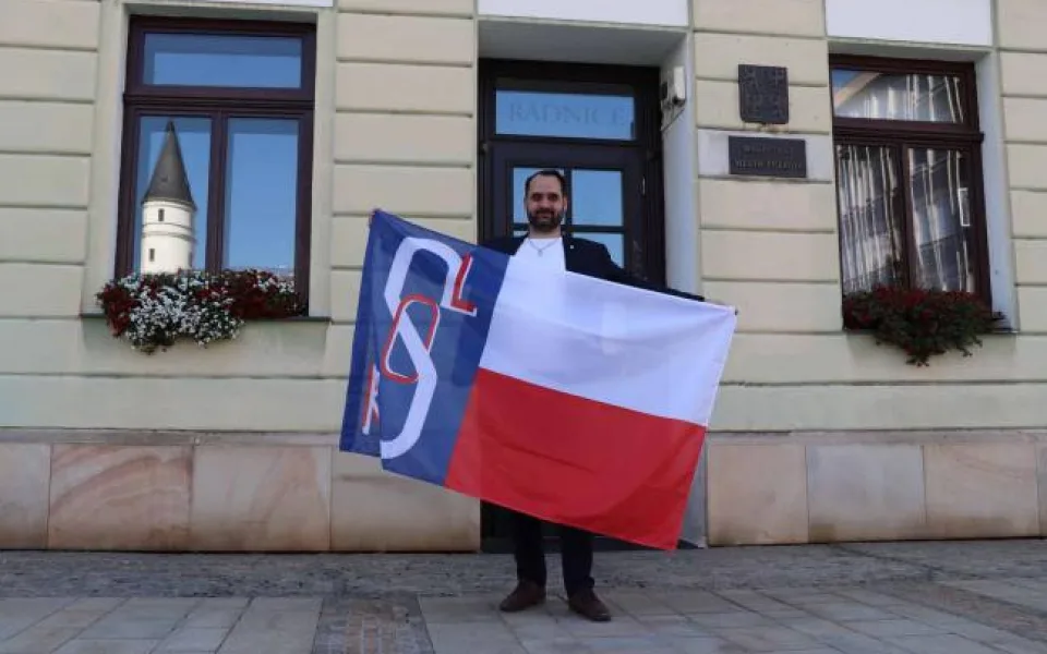 Jakub Navařík drží sokolskou vlajku.
