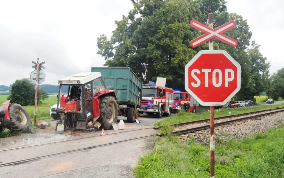 Projíždějící vlak smetl traktor, ten se po nárazu rozlomil.