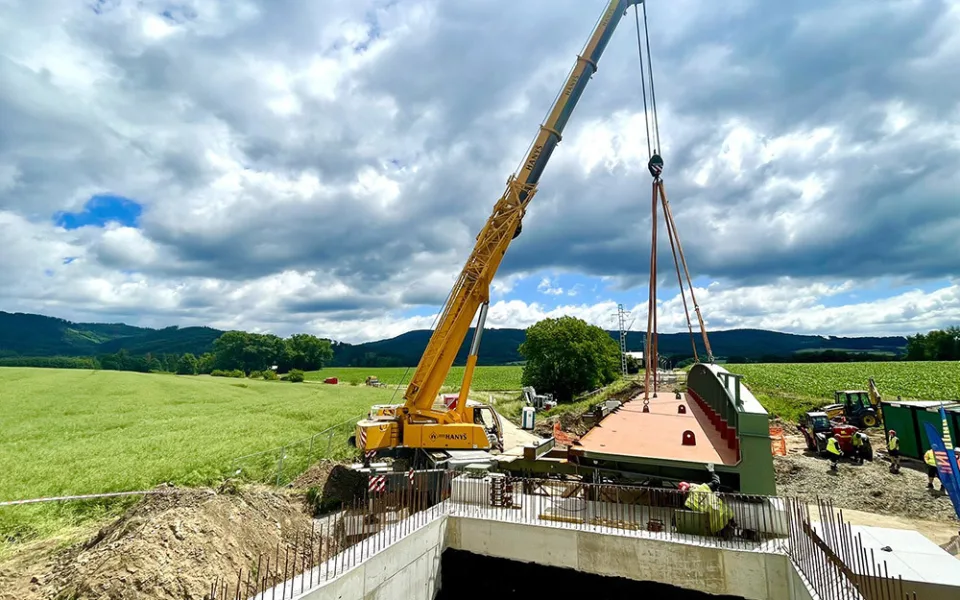 Instalace konstrukcí nového železničního mostu, kterým se zvýší i podjezd pro auta pod tratí
