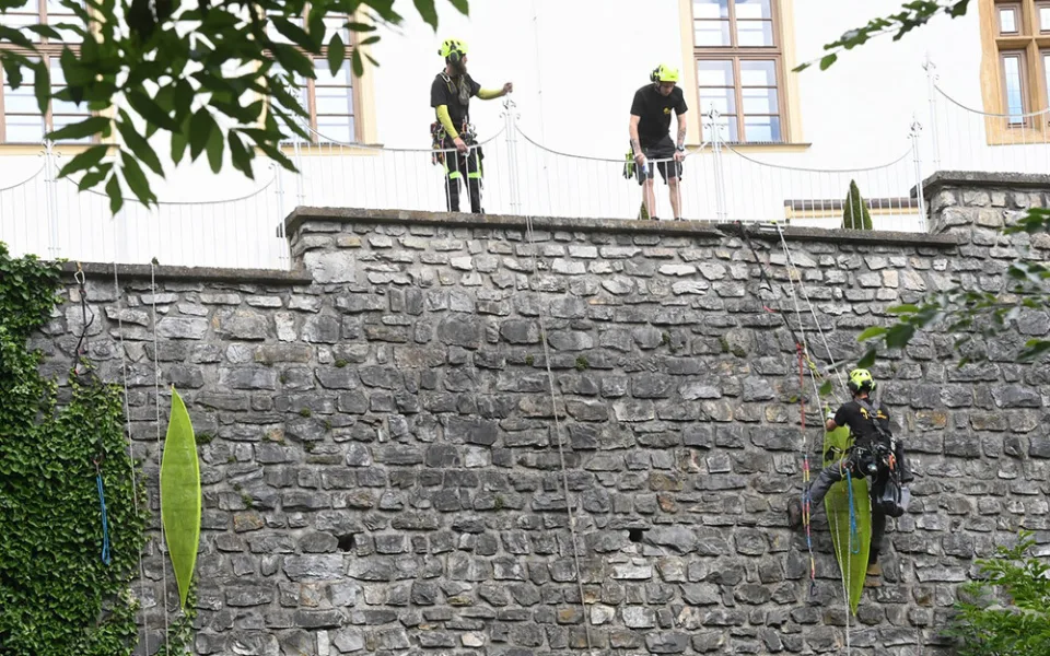 Specialisté pro výškové práce při instalaci prvních z pěti objektů německého výtvarníka Johannese Pfeiffera s názvem Záchranné čluny na kamennou zeď v Bezručových sadech