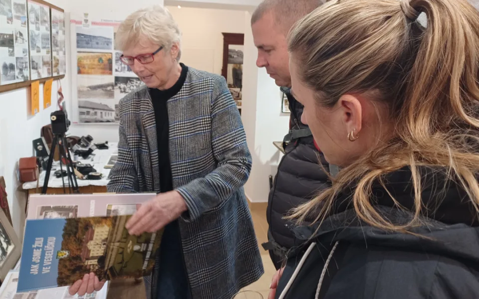 Kurátorka Muzea Záhoří na Veselíčku Stanislava Čočková ukazuje návštěvníkům novou knihu o historii vesnice.