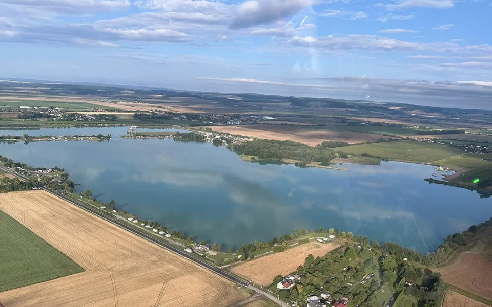 Pohled na pískovnu Náklo a v dolní části nalevo na opravenou silnici III/44620