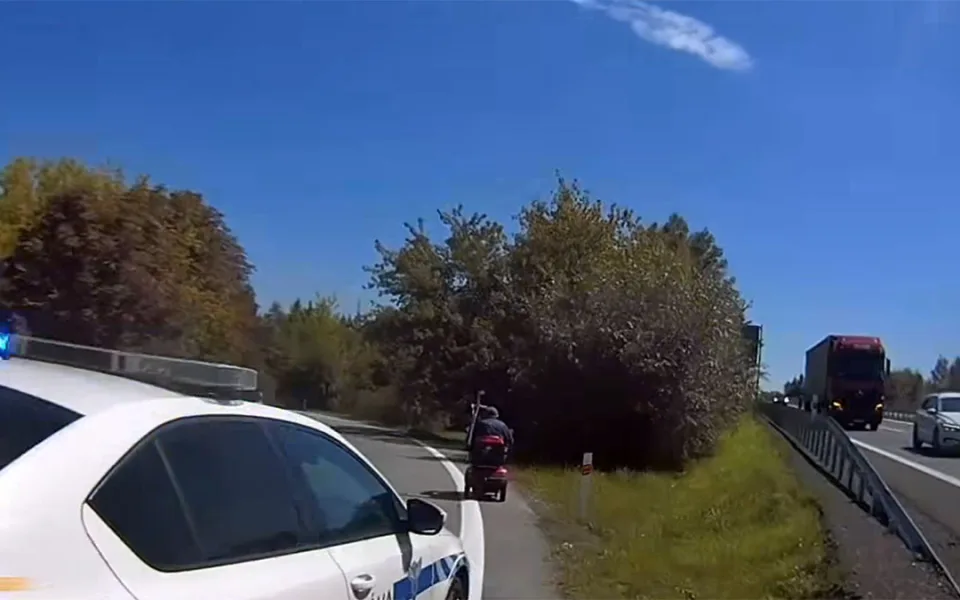 Hlídka celní správy doprovází seniora na elektrickém vozíku z dálnice D35