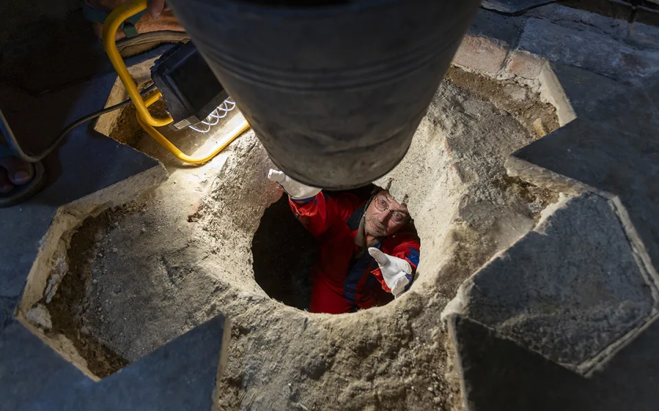Archeolog Robert Zatloukal si bere nádobu pro uložení dalšího materiálu z podzemní místnosti pod kaplí